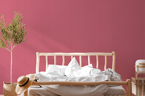 Pinke Tapete hinter einem hellen Bett